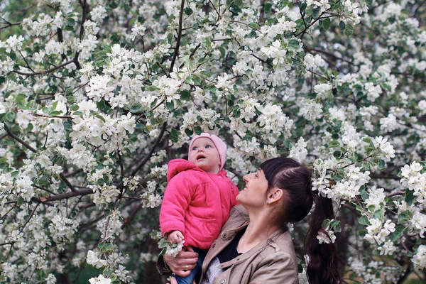 Дівчина з дочкою в весняному яблучному саду — стокове фото