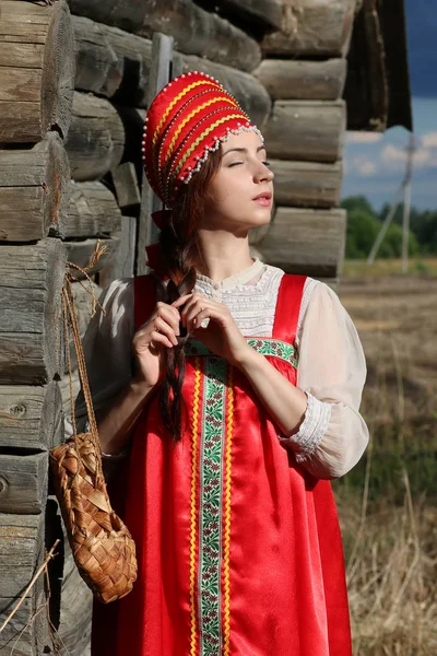전통적인 드레스 나무 벽에 여자 — 스톡 사진