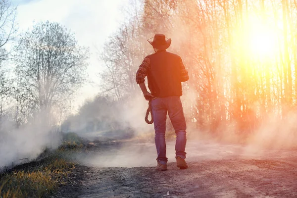 Człowiek nosi kowbojski kapelusz i loso w polu. Amerykański — Zdjęcie stockowe