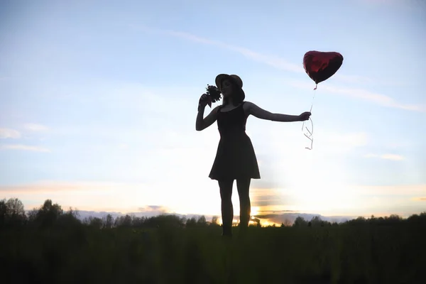 Una ragazza con un cappello mentre passeggia nel parco. Una ragazza con un cesto a piedi — Foto Stock