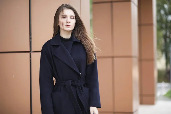 Menina bonita em um casaco no centro de negócios — Fotografia de Stock