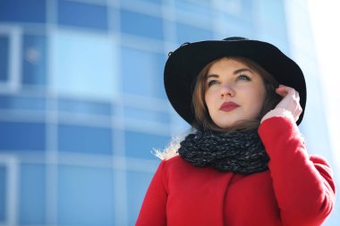 Bir arka plan cam kırmızı paltolu şirin iş kadını