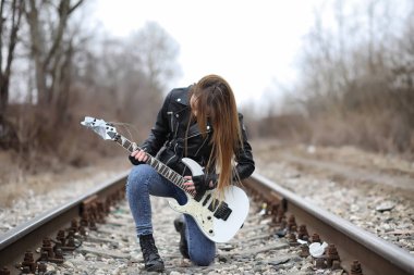  A rock musician girl in a leather jacket with a guitar  clipart
