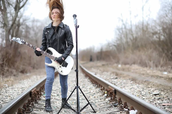 A rock musician girl in a leather jacket with a guitar — Stock Photo, Image