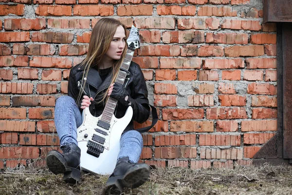 A rock musician girl in a leather jacket with a guitar — Stock Photo, Image