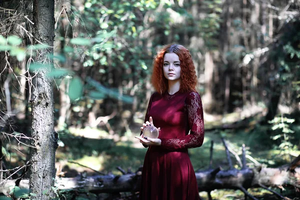 The red-haired witch holds a ritual with a crystal ball — Stock Photo, Image