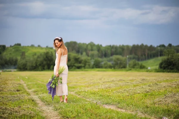 Girl with a bouquet of blue flowers — Stock Photo, Image