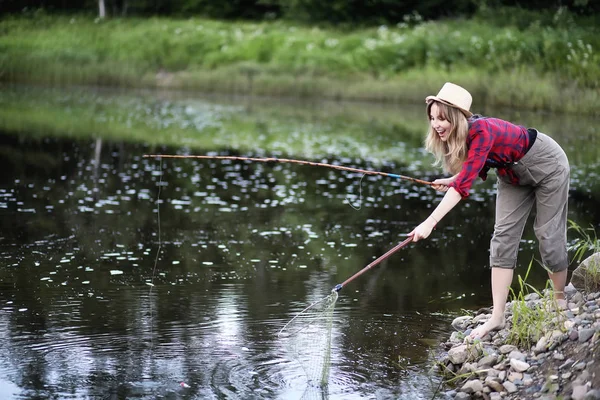 Fille au bord de la rivière avec une canne à pêche — Photo