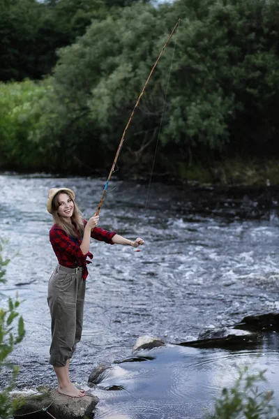 Flickan vid floden med ett fiskespö — Stockfoto