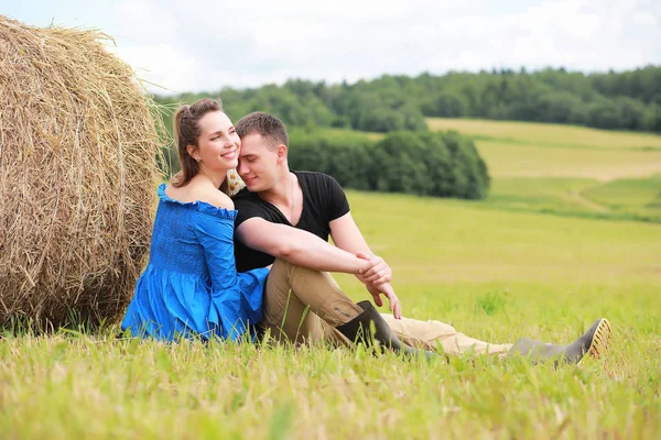 Couple amoureux dans un champ au coucher du soleil — Photo