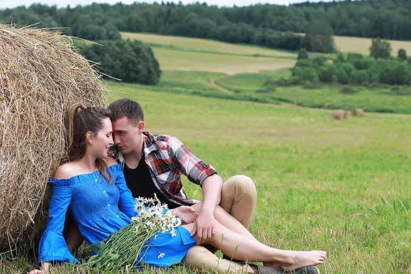 Couple amoureux dans un champ au coucher du soleil — Photo