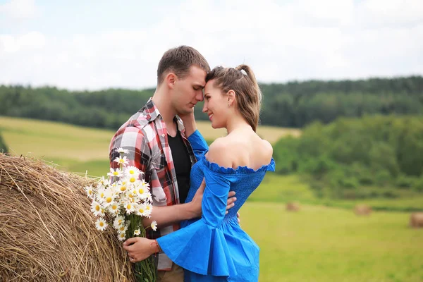 Couple in love in a field at sunset — Stock Photo, Image