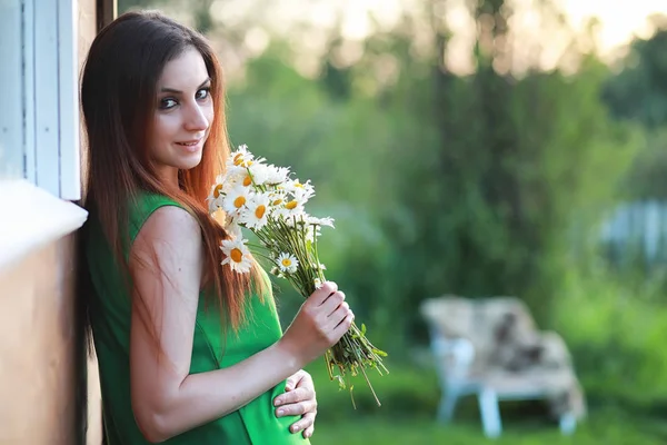 Schöne Mädchen mit roten Haaren mit einem Strauß — Stockfoto