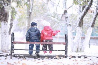 Çocuklar parkta ilk kar yürümek