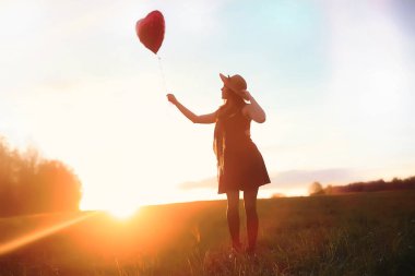 Parkta bir yürüyüş üzerinde şapkalı bir kız. Bir kızla bir sepet yürüyüş