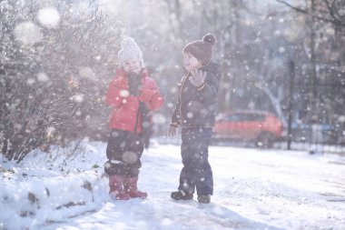 Çocuklar parkta ilk kar yürümek