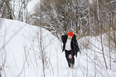 Kışın ormanda bir adam. Sırt çantalı bir turist.