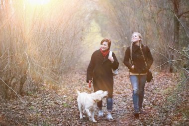 Anne ve genç kız sonbahar bahçesinde yürüyüşe çıktılar.