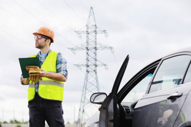 Kasklı ve üniformalı bir adam, sahada bir elektrikçi. Profesör.