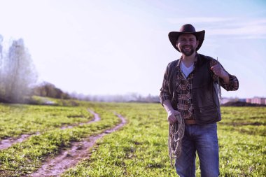 Bir alanda gün batımında ayakta kovboy