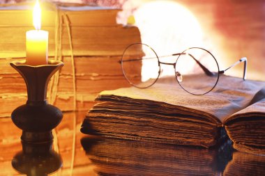 Ay 'ın arka planında eski bir retro kitapta antika gözlükler