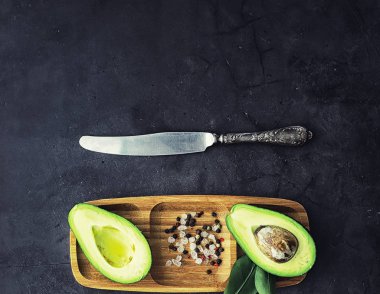 Avokado yemek tarifleri. Olgun yeşil avokado ahşap bir kesim üzerinde 