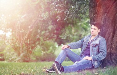 Genç bir adam öğle yemeği zamanında parkta yürür. Bir adam yürüyüşe çıktı. 