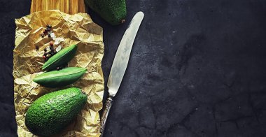 Avokado yemek tarifleri. Olgun yeşil avokado ahşap bir kesim üzerinde 