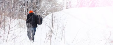 Kışın ormanda bir adam. Sırt çantalı bir turist.