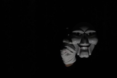 Siyah arka planda beyaz, korkunç bir maske..