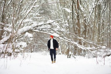 Kışın ormanda bir adam. Sırt çantalı bir turist.