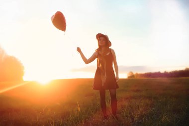 Parkta bir yürüyüş üzerinde şapkalı bir kız. Bir kızla bir sepet yürüyüş