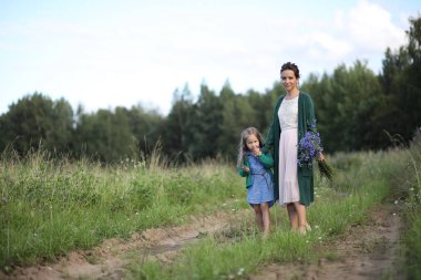 Anne ve kızı yolda yürüyor.