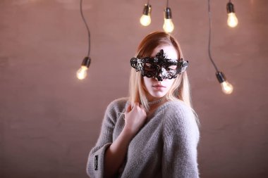 Siyah bir maske içinde sarı saçlı bir kızla