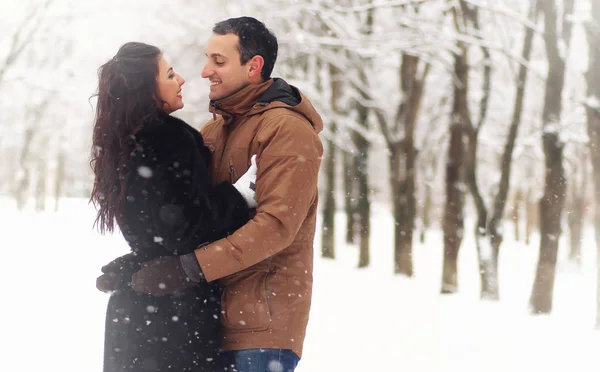 一对年轻夫妇在雪地的冬季公园约会 — 图库照片