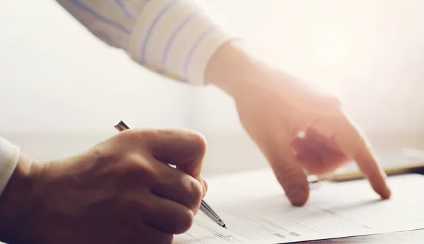 Reunión de negocios. Un hombre firma un contrato. Mano masculina con pluma mak —  Fotos de Stock