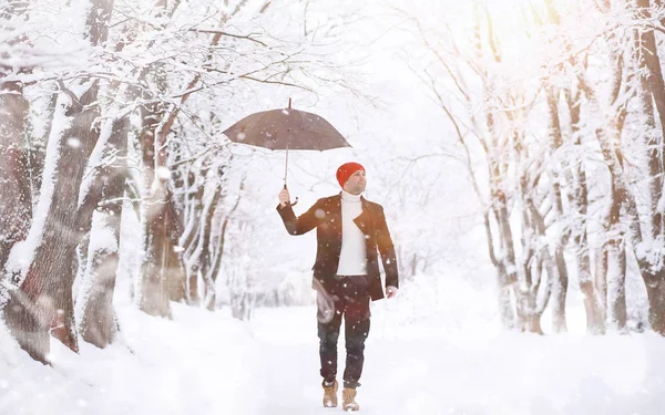 Um homem a passear no parque. Jovem com no inverno snowfa — Fotografia de Stock