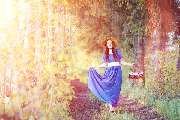 Молодая красивая девушка в платьях на природе. Девушка в шляпе ходит — стоковое фото