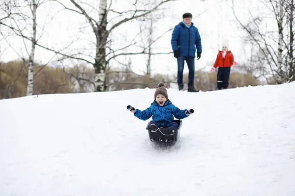Gyerekek a parkban télen. Gyerekek játszanak a hóval a játszótéren. — Stock Fotó