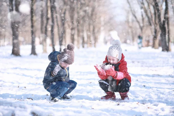 Çocuklar parkta ilk kar yürümek — Stok fotoğraf