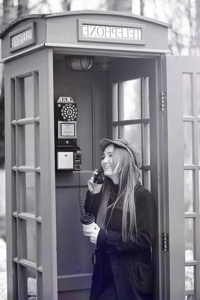 Hermosa jovencita en una cabina telefónica. La chica está hablando en th — Foto de Stock