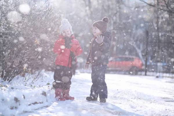 Los niños caminan en el parque primera nieve — Foto de Stock