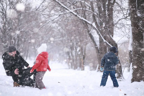 Los niños caminan en el parque primera nieve —  Fotos de Stock