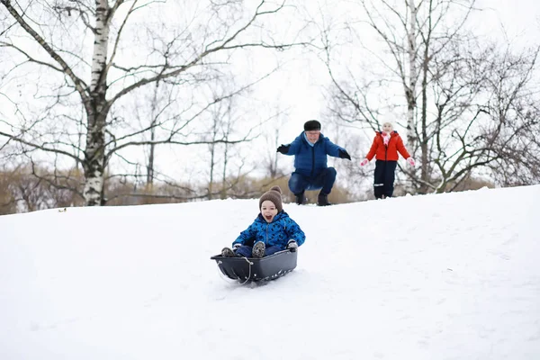 Gyerekek a parkban télen. Gyerekek játszanak a hóval a játszótéren. — Stock Fotó