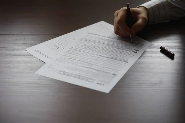 Reunião de negócios. Um homem assina um contrato. Mão masculina com caneta mak — Fotografia de Stock