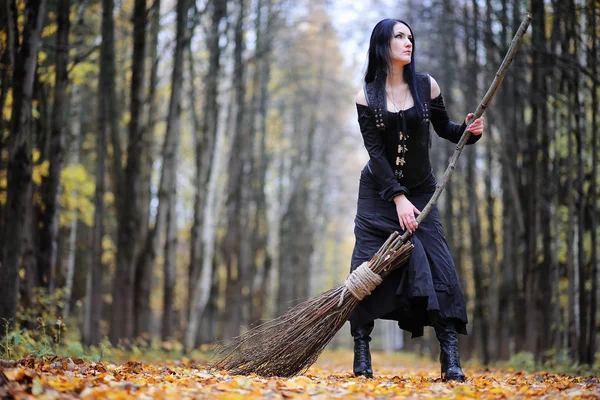 Une femme en costume de sorcière dans une forêt — Photo