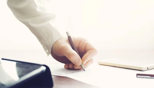 Zakelijke bijeenkomst. Een man tekent een contract. Mannelijke hand met pen mak — Stockfoto