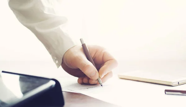 Reunión de negocios. Un hombre firma un contrato. Mano masculina con pluma mak —  Fotos de Stock