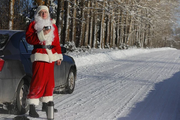 Santa Claus comes with gifts from the outside. Santa in a red su — Stock Photo, Image