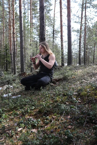 Um músico com uma ferramenta na natureza. Um homem está tocando uma flauta em um — Fotografia de Stock